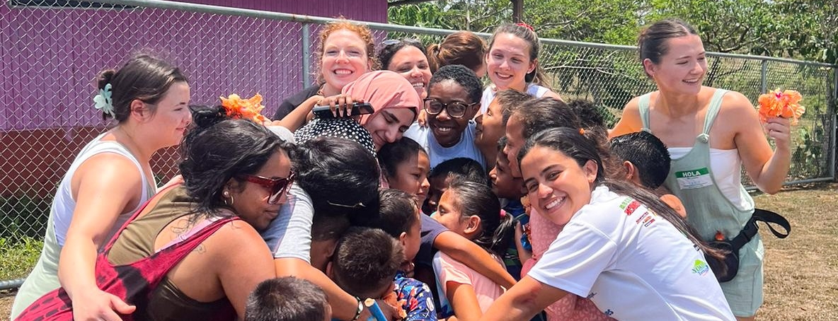 Students in Nicaragua join a group-hug with children 